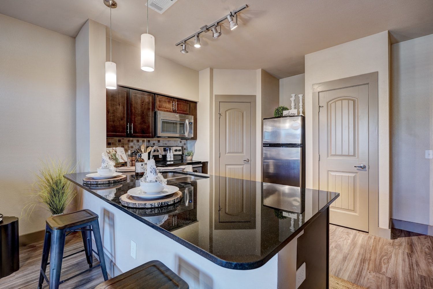 A kitchen with granite countertops, stainless steel appliances, and a refrigerator.
