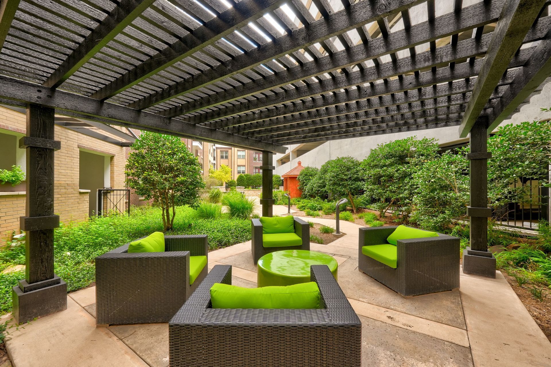 A patio area with chairs and a table under a pergola.