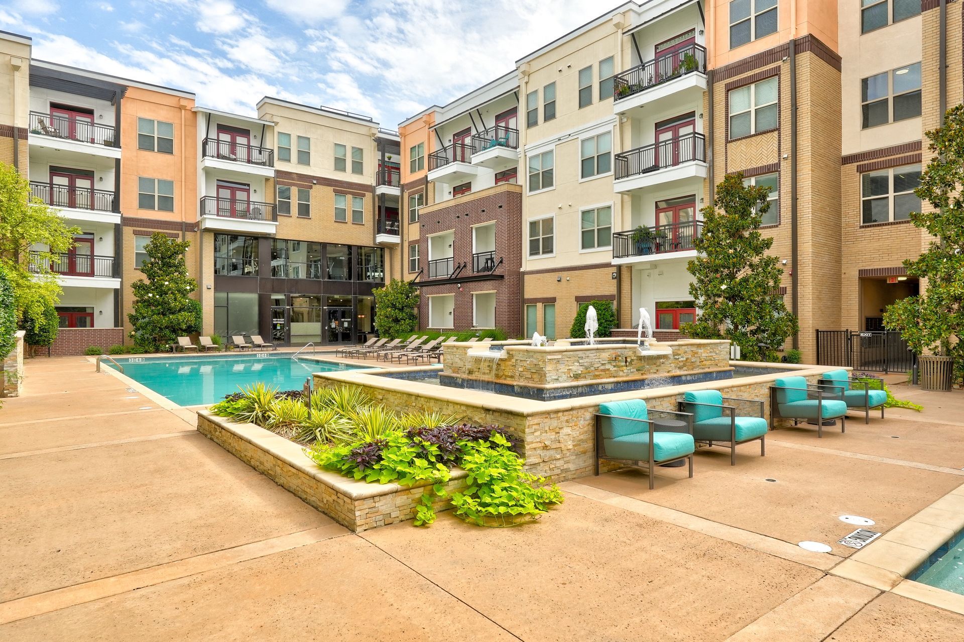 A large apartment building with a swimming pool in the middle of it.