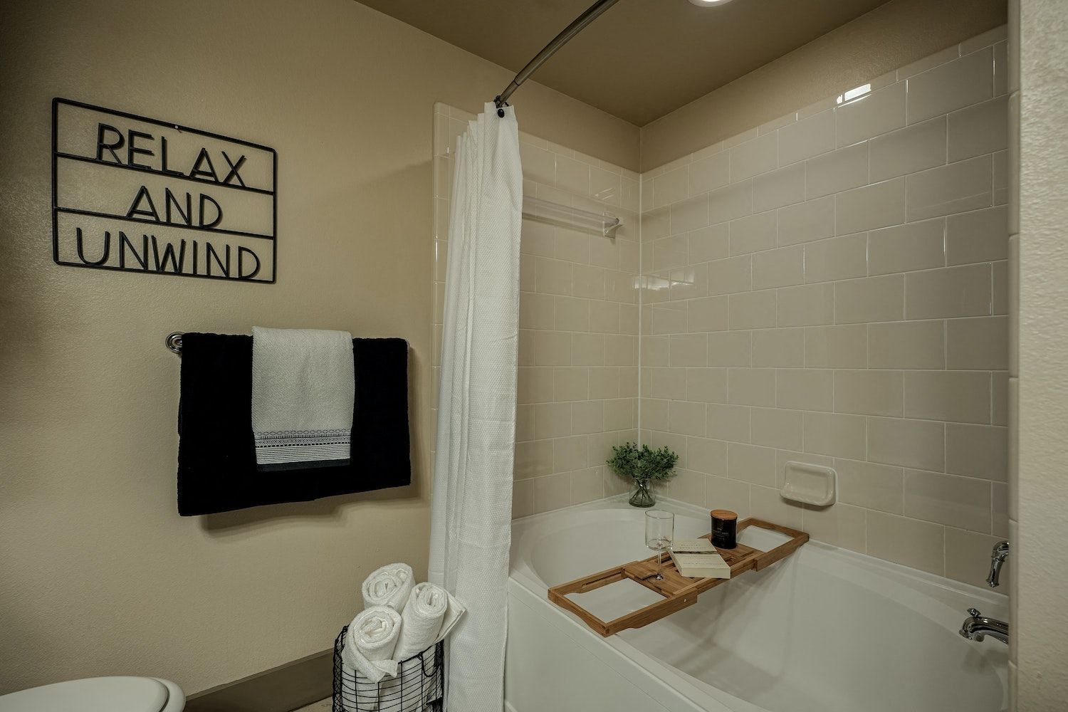 A bathroom with a bathtub and a sign that says `` relax and unwind ''.