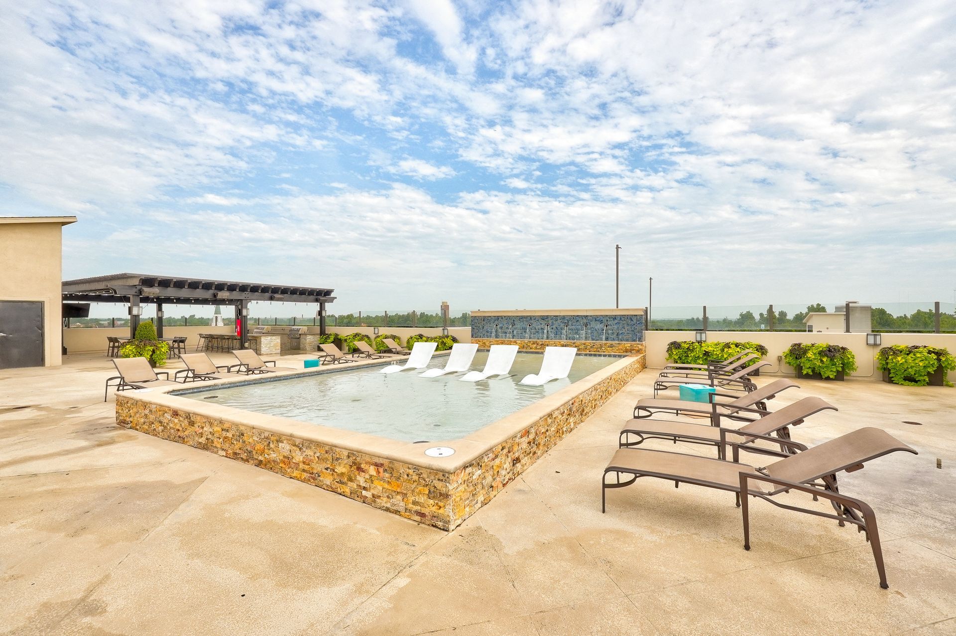 A large swimming pool with a lot of chairs around it.