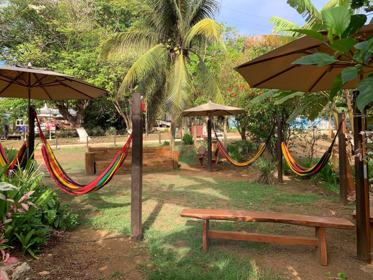 Um monte de redes estão sob guarda-sóis em um parque.