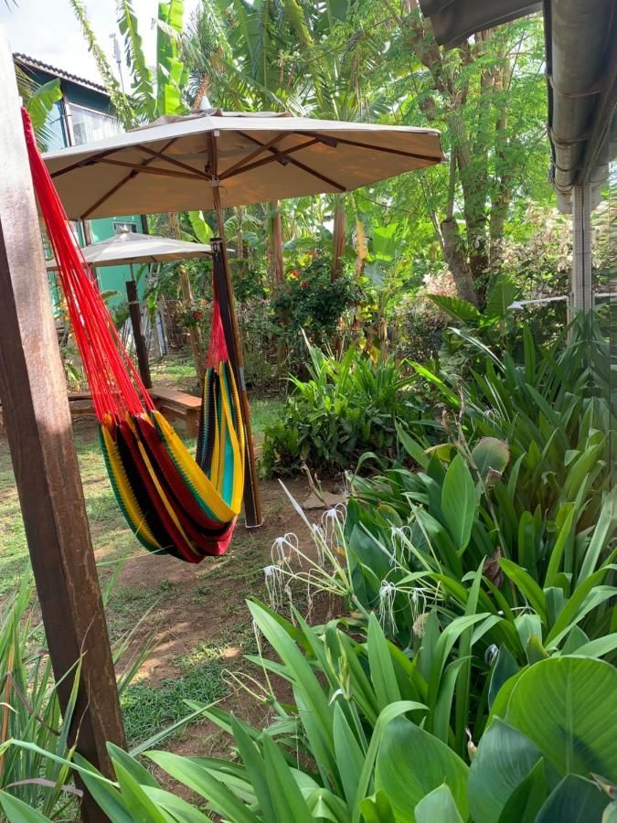 Uma rede está pendurada sob um guarda-chuva em um jardim.