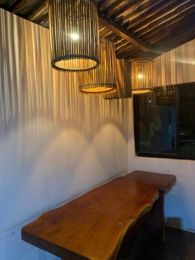 Uma mesa de madeira em uma sala com uma janela e luzes penduradas.