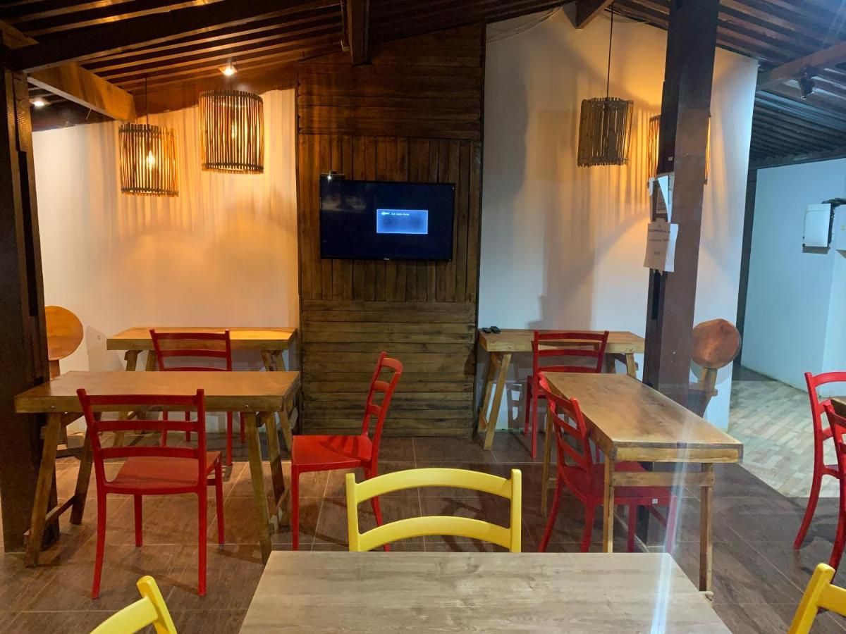 Um restaurante com mesas e cadeiras e uma televisão na parede.