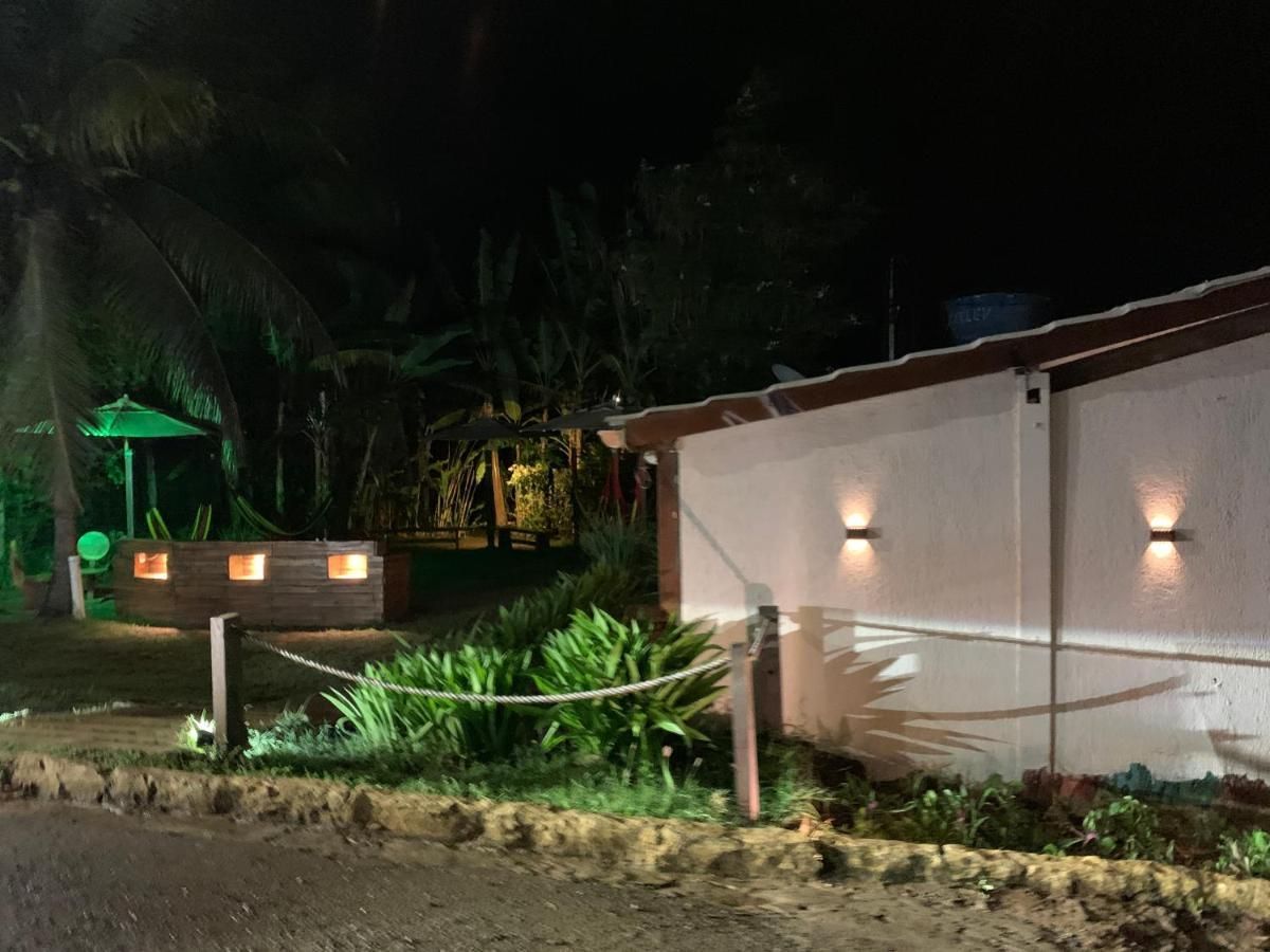 Uma cerca iluminada à noite em frente a uma casa.