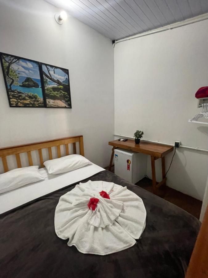 Um quarto com uma cama, uma escrivaninha e um quadro na parede.