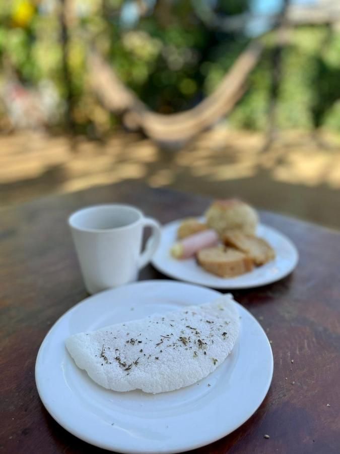 Um prato de comida e uma xícara de café sobre uma mesa.