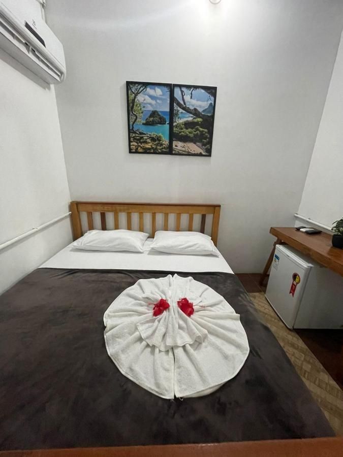 Há uma cama com uma toalha enrolada em volta dela em um quarto de hotel.