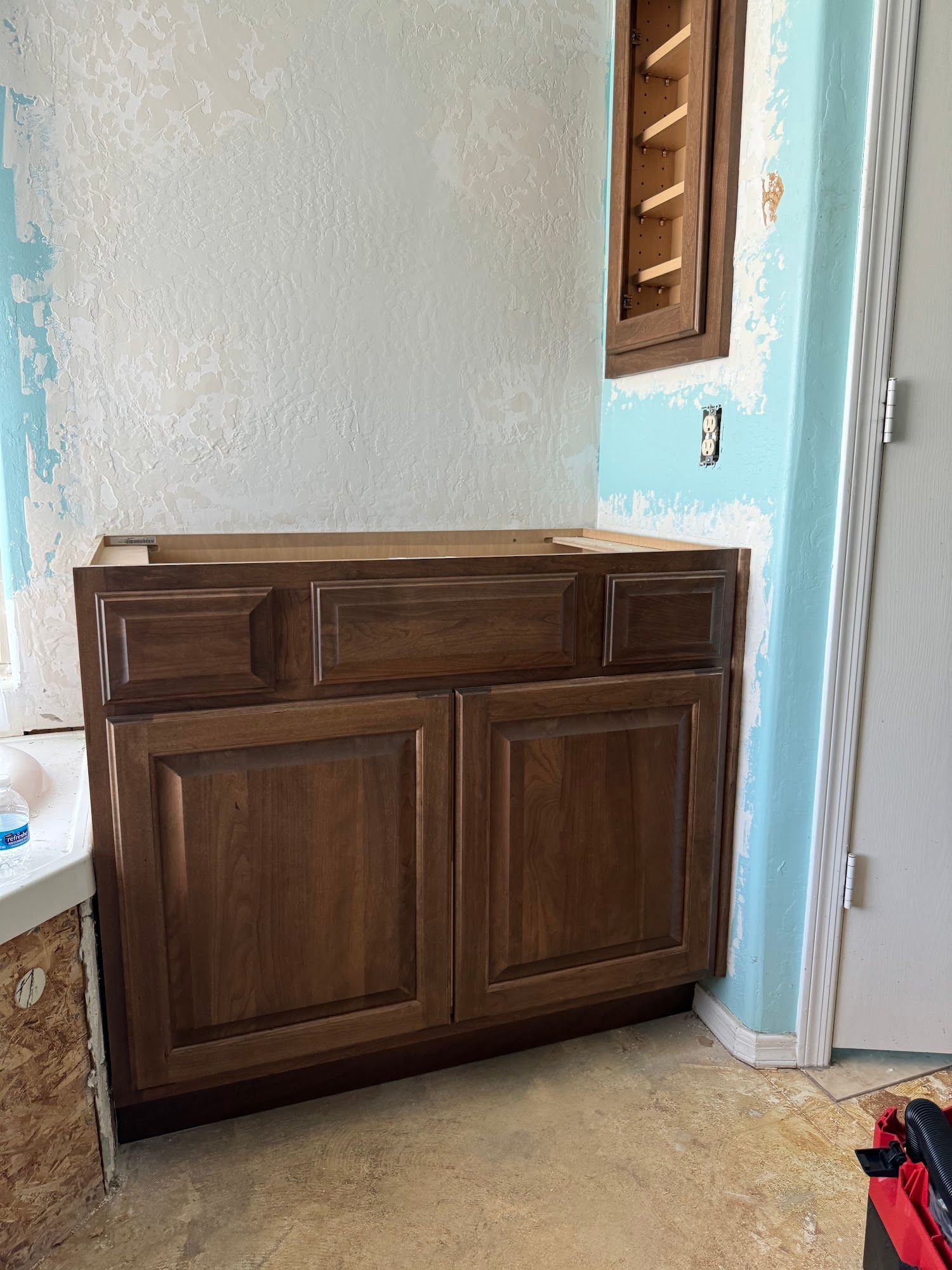 Dark brown bathroom vanity installed on a wall with blue and white paint.