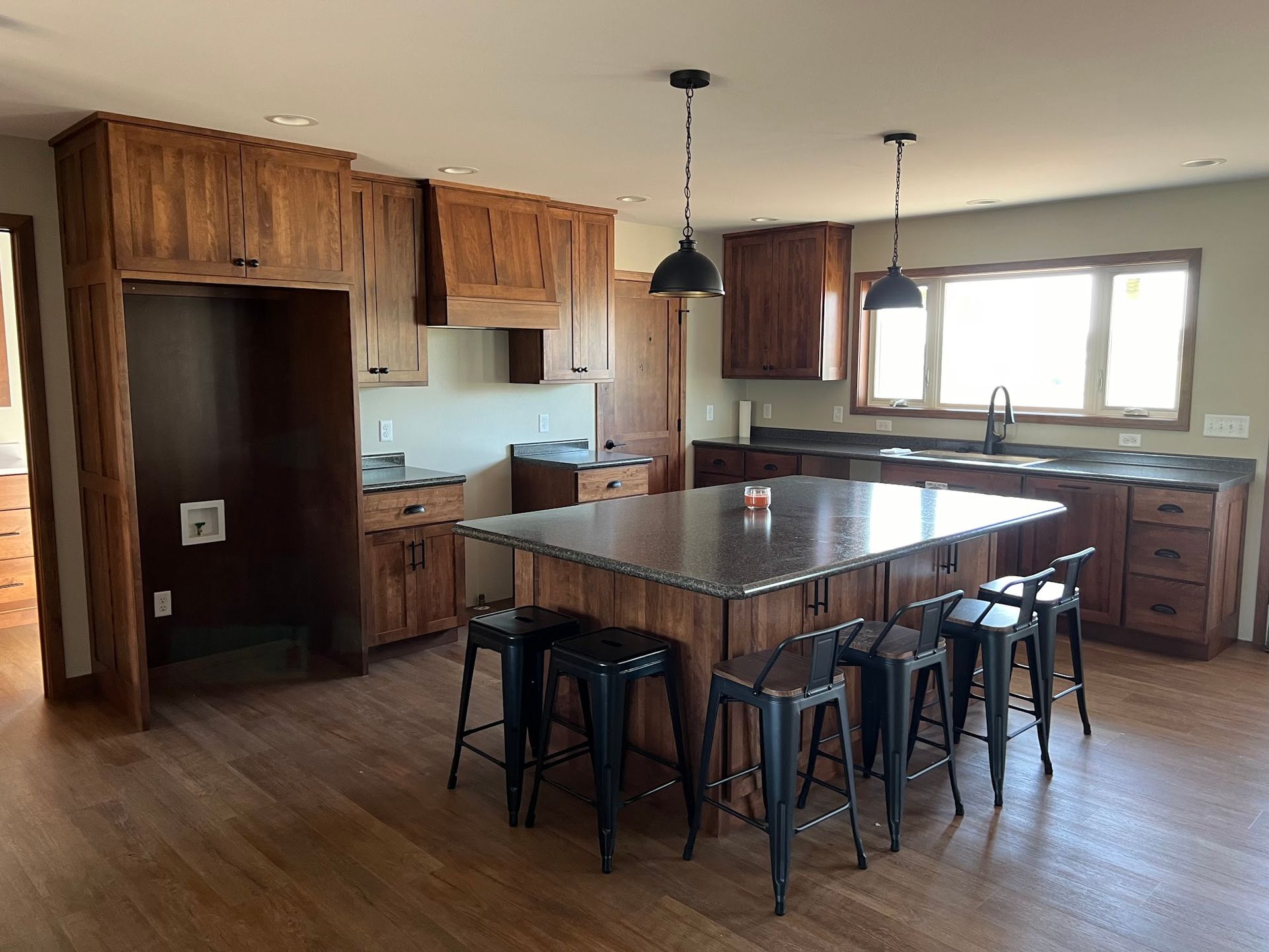 Wooden floating staircase with black railing against a concrete wall, in a modern interior.