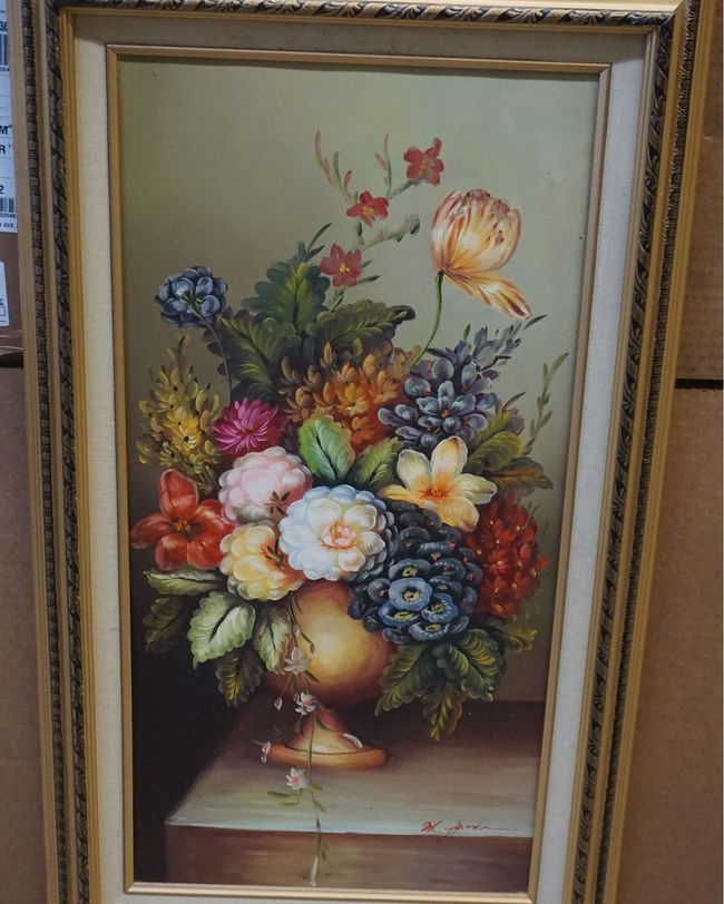 A framed painting of flowers in a vase on a table