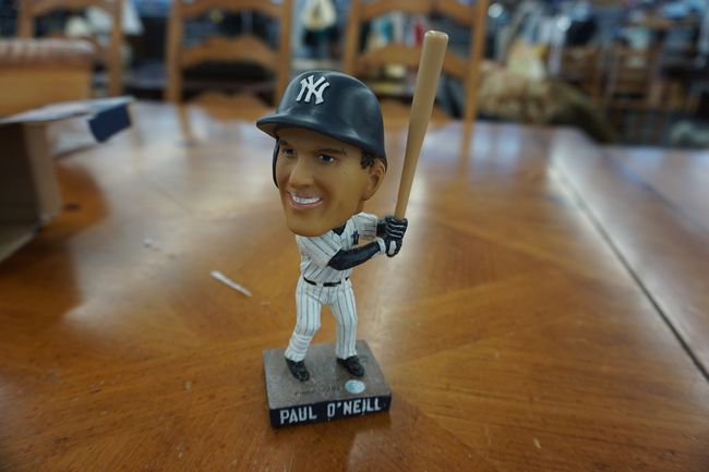 A bobble head of a baseball player holding a bat on a table.