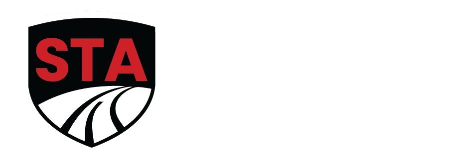 The STA logo: a black shield with red 