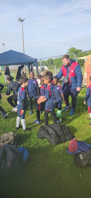 Un groupe de jeunes garçons jouent au football sur un terrain.