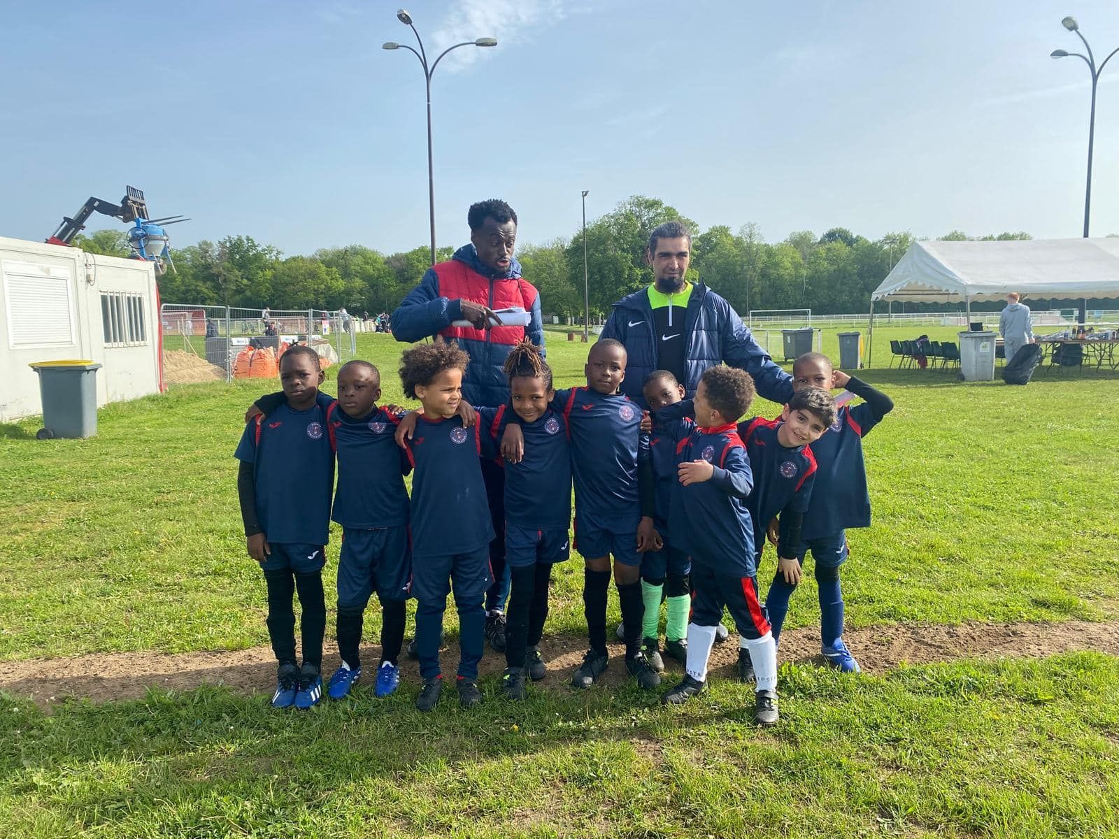 Un groupe de jeunes garçons posent pour une photo sur un terrain de football.