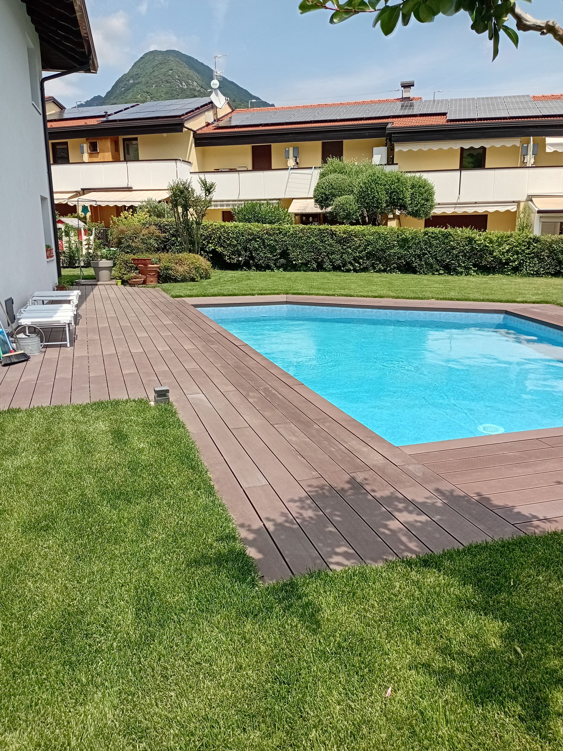 Una grande piscina in un cortile con una casa sullo sfondo