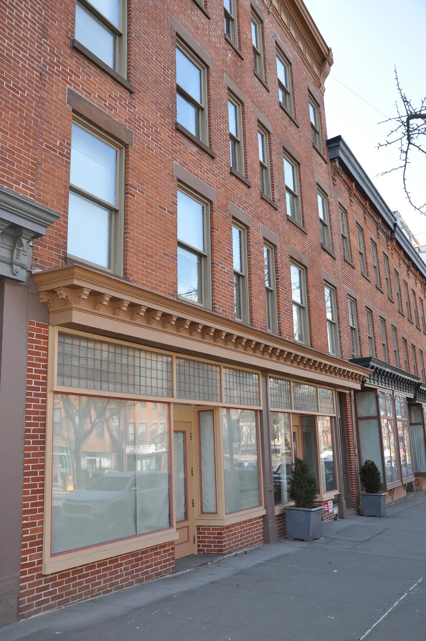 Brick buildings with storefronts, wooden accents, and multiple windows along a street.