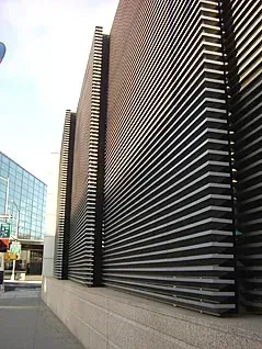 Modern building exterior with black horizontal slatted design on a gray stone base