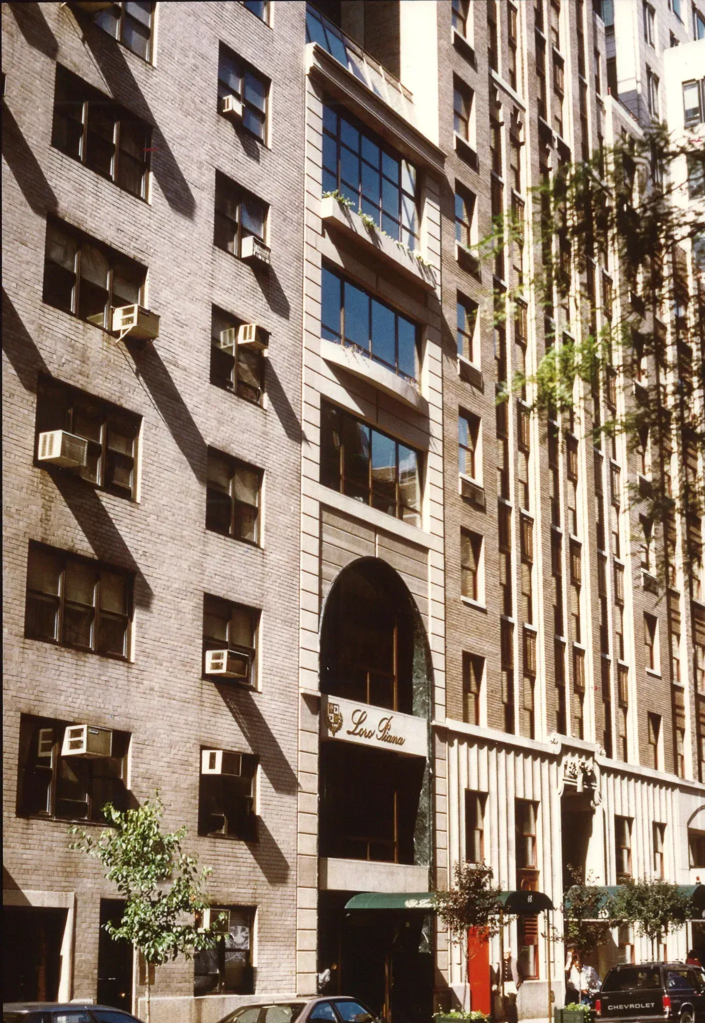 Exterior of a tall brick apartment building on a city street.