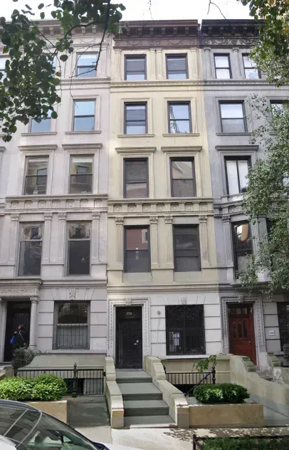 Row of beige and grey townhouses with steps leading up to the front doors, trees on the side and in front.