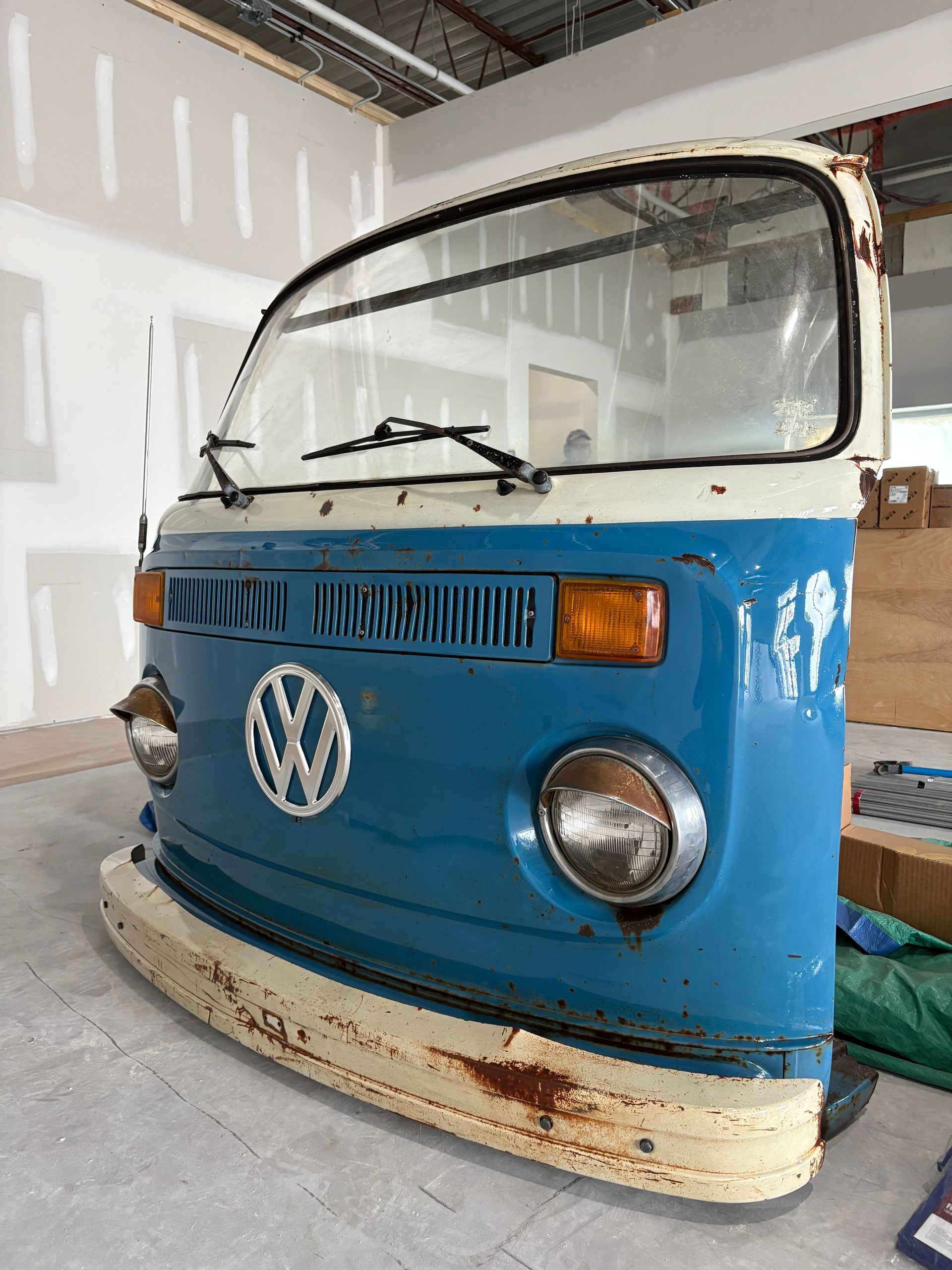 Tennis racket and ball on a clay court, casting shadows in the sunlight.