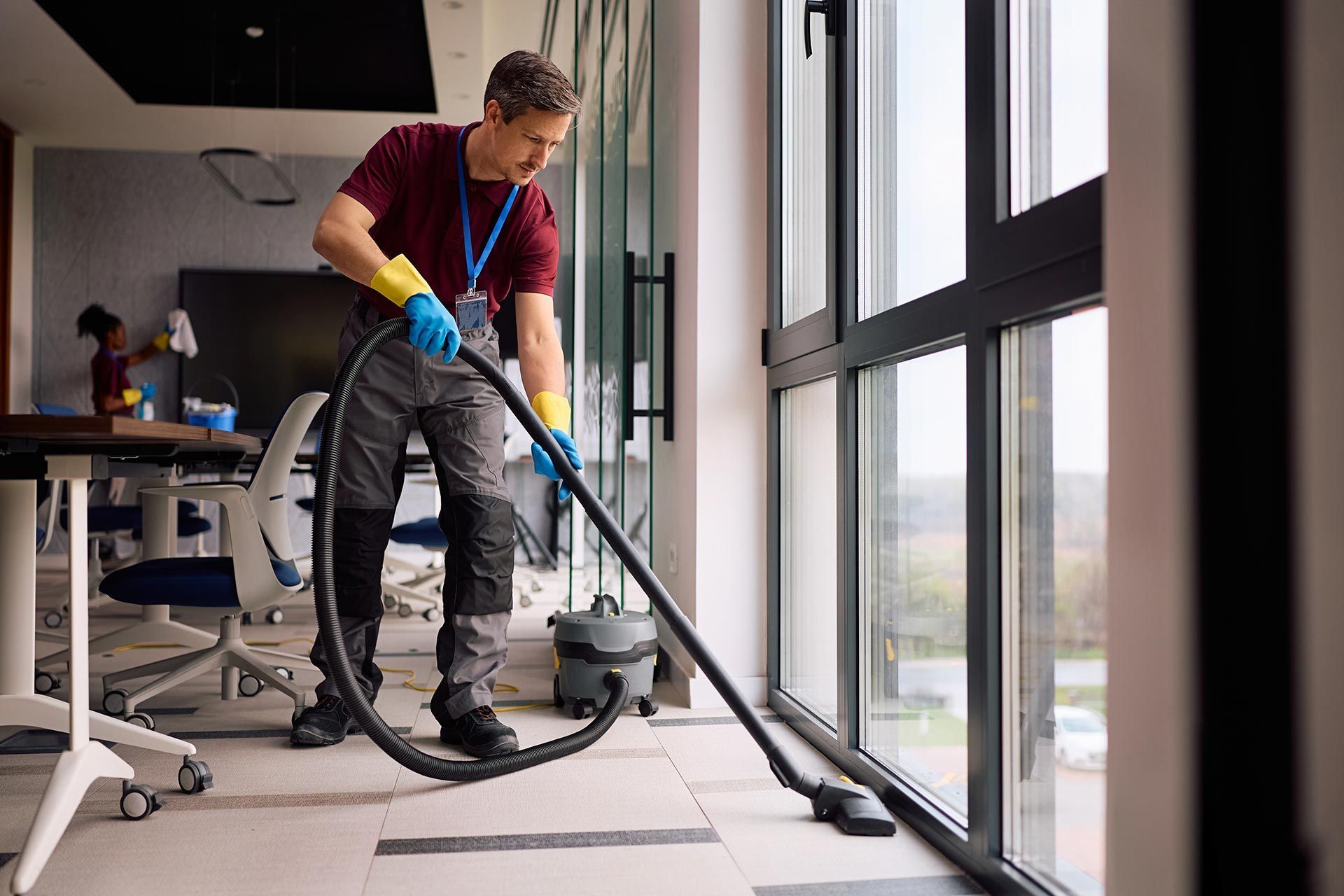 Professional cleaner vacuuming floors in modern office building. Professional cleaner vacuuming floors in modern office building.