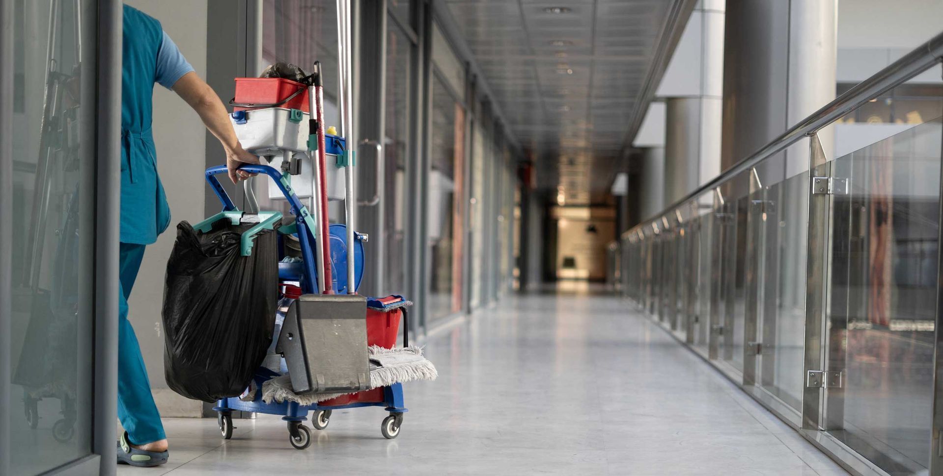 An employee pulls a trolley for cleaning offices.
