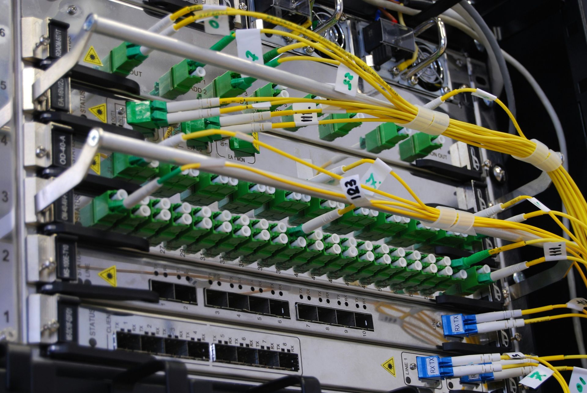 Gros plan d'un rack de serveur réseau avec câbles et connecteurs à fibre optique dans un centre de données.