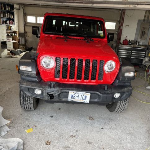 A red jeep is parked in a garage.