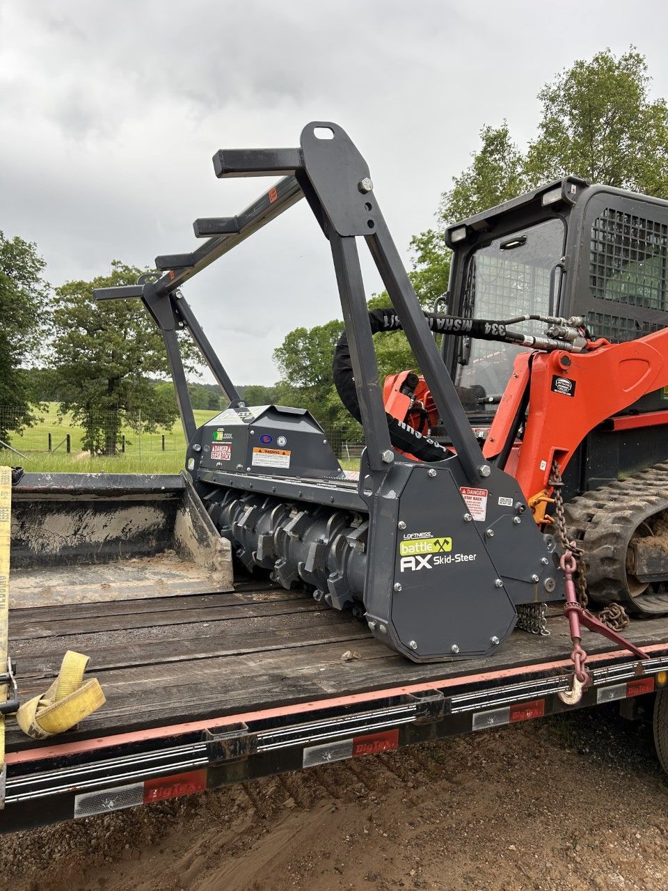 A tractor is sitting on top of a trailer.
