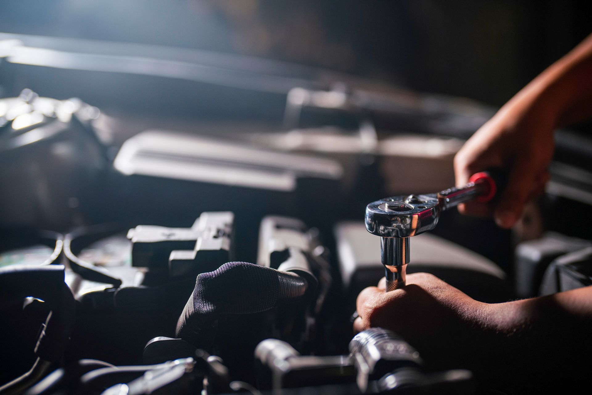Professional mechanic working on the engine of the car in the garage.