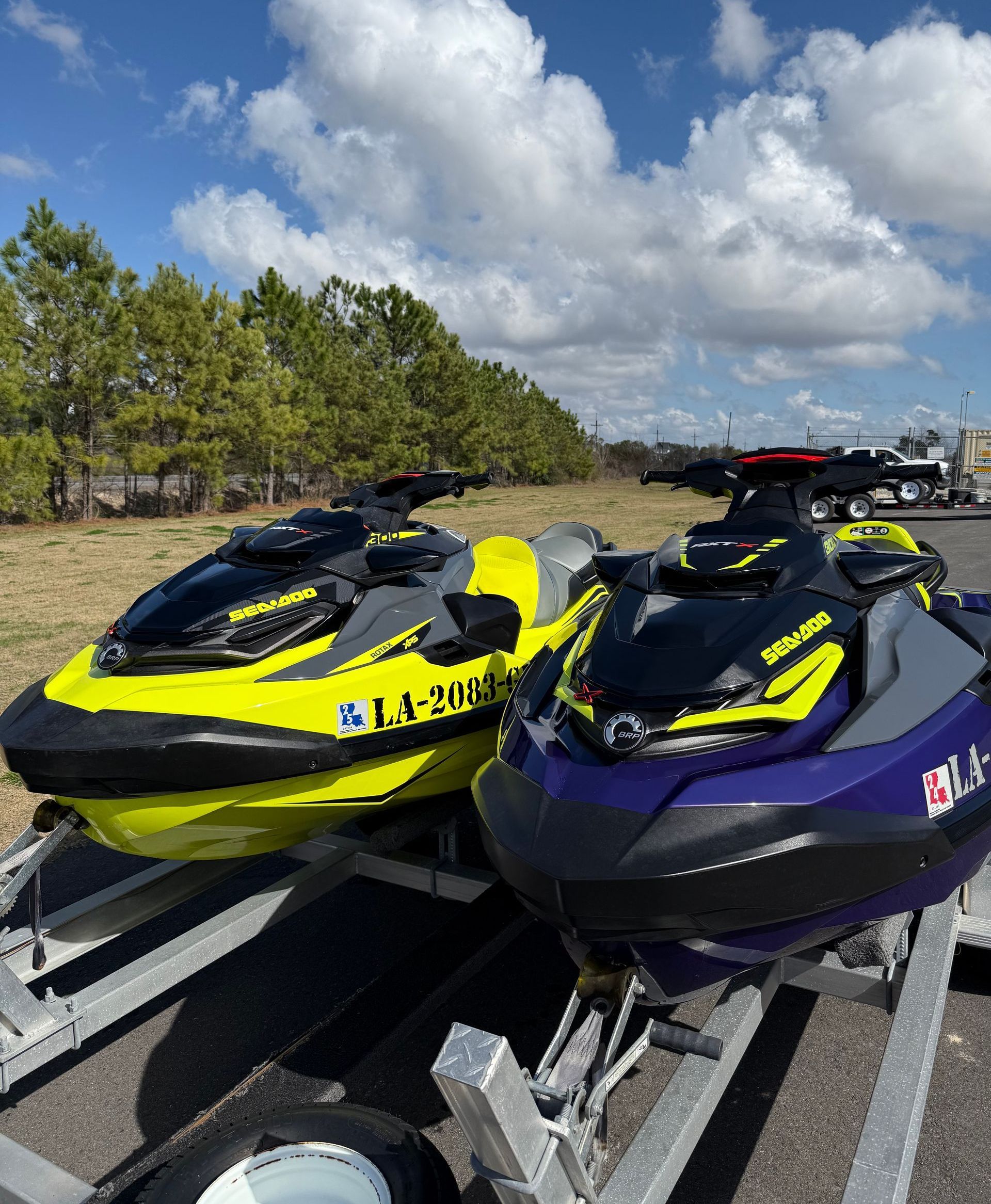 Two jet skis are parked next to each other on a trailer.