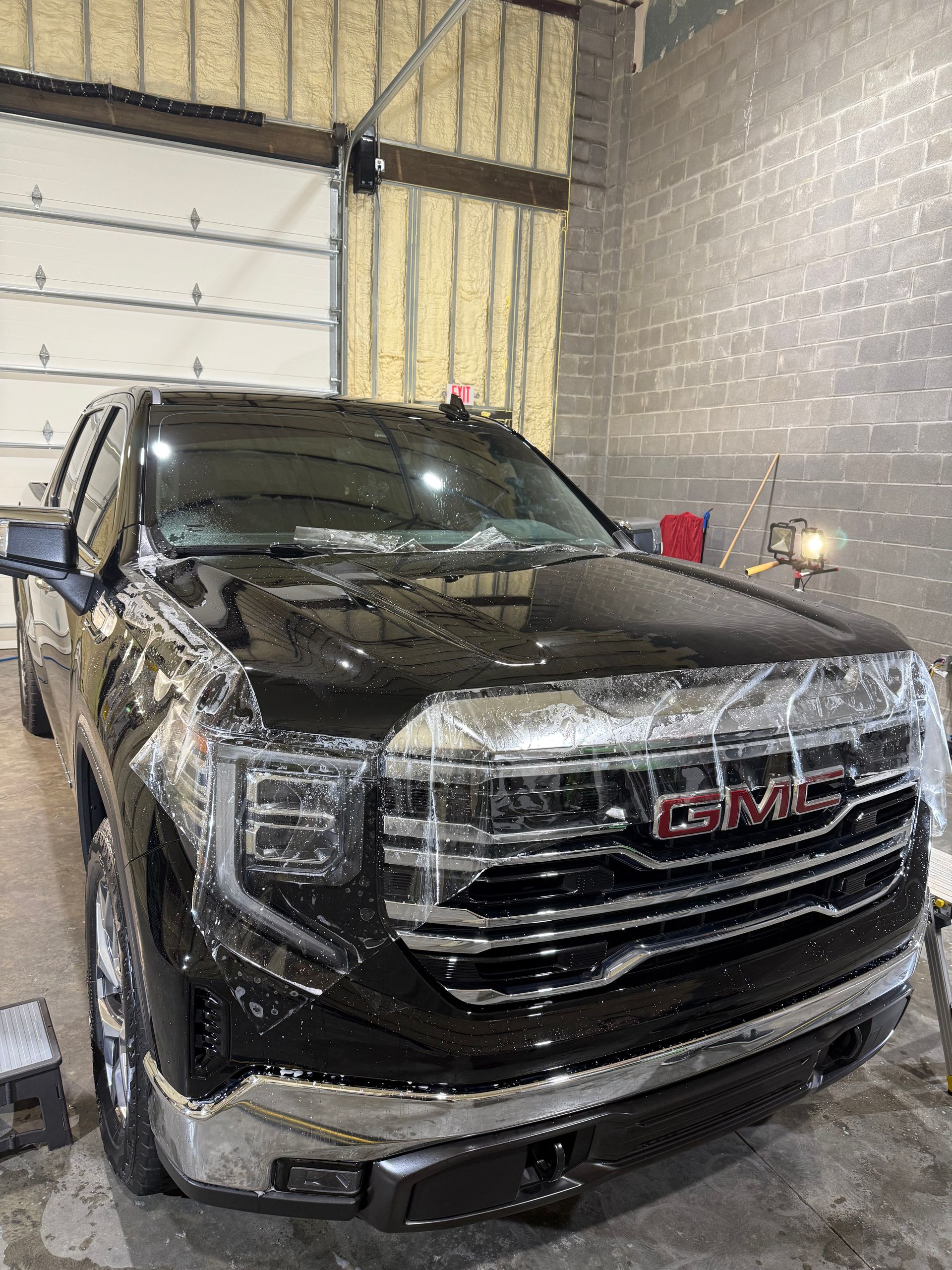 A black gmc truck is parked in a garage.