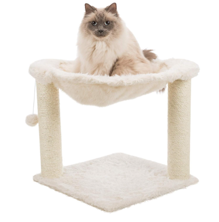 A cat is sitting in a white hammock on a scratching post