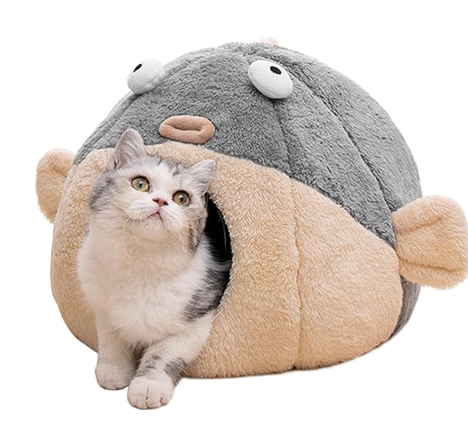A cat is sitting in a fish shaped cat bed.