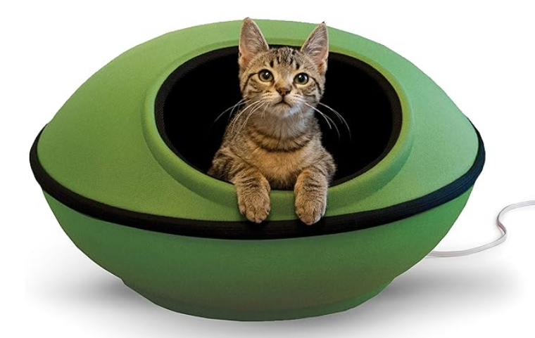 a cat is laying in a green bowl with a cord coming out of it