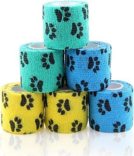 six rolls of bandages with paw prints on them are stacked on top of each other .