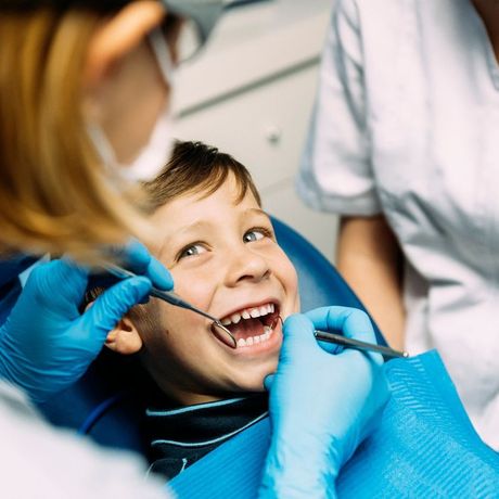 A young boy is getting his teeth examined by a dentist