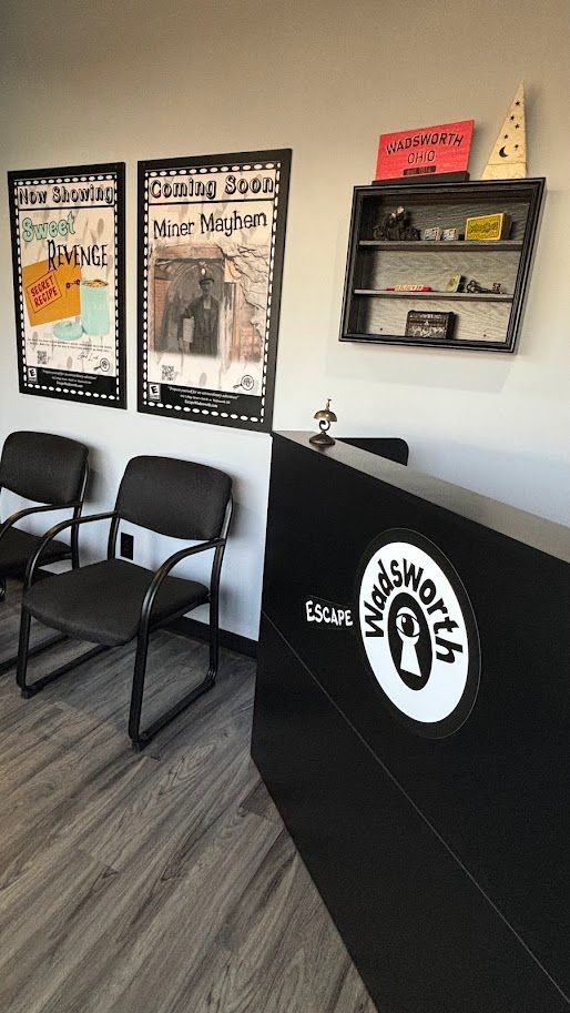 A waiting room with chairs , a counter and a shelf.