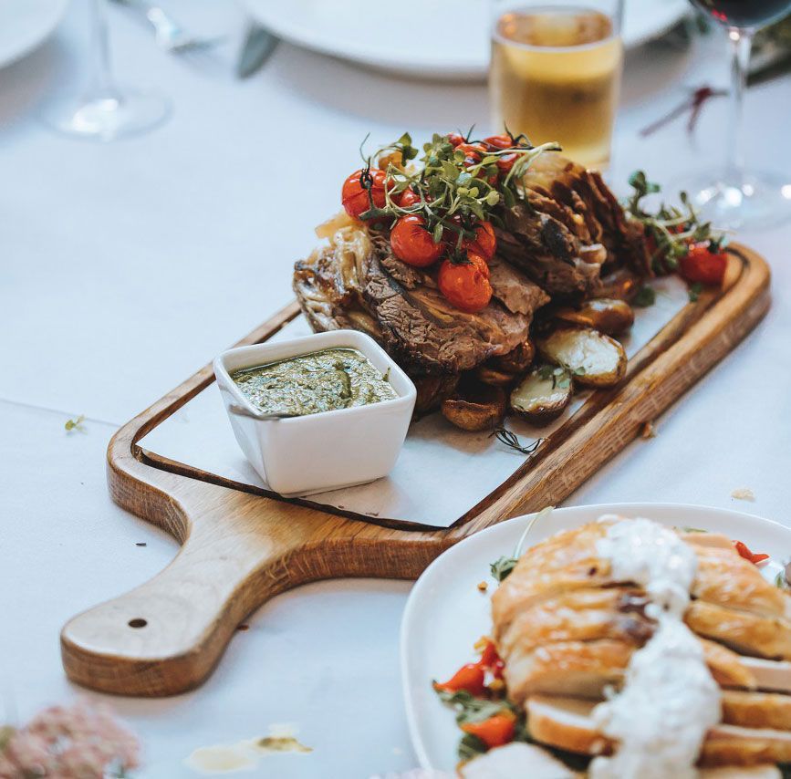 a wooden cutting board with meat and vegetables on it