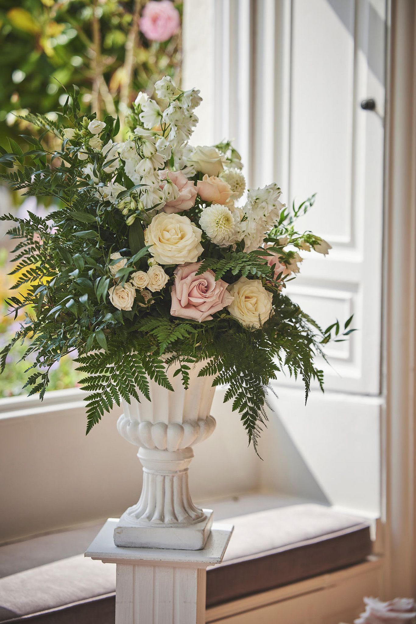 a vase filled with flowers is sitting in front of a window .