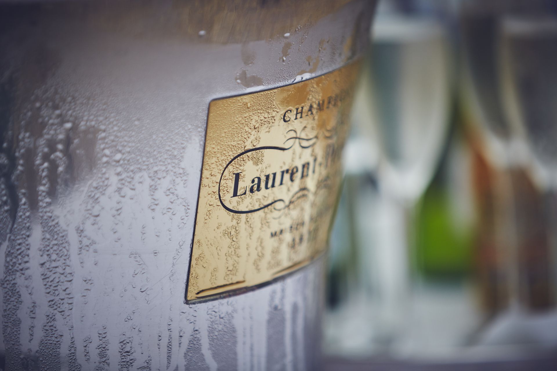 two women are carrying trays of champagne glasses .