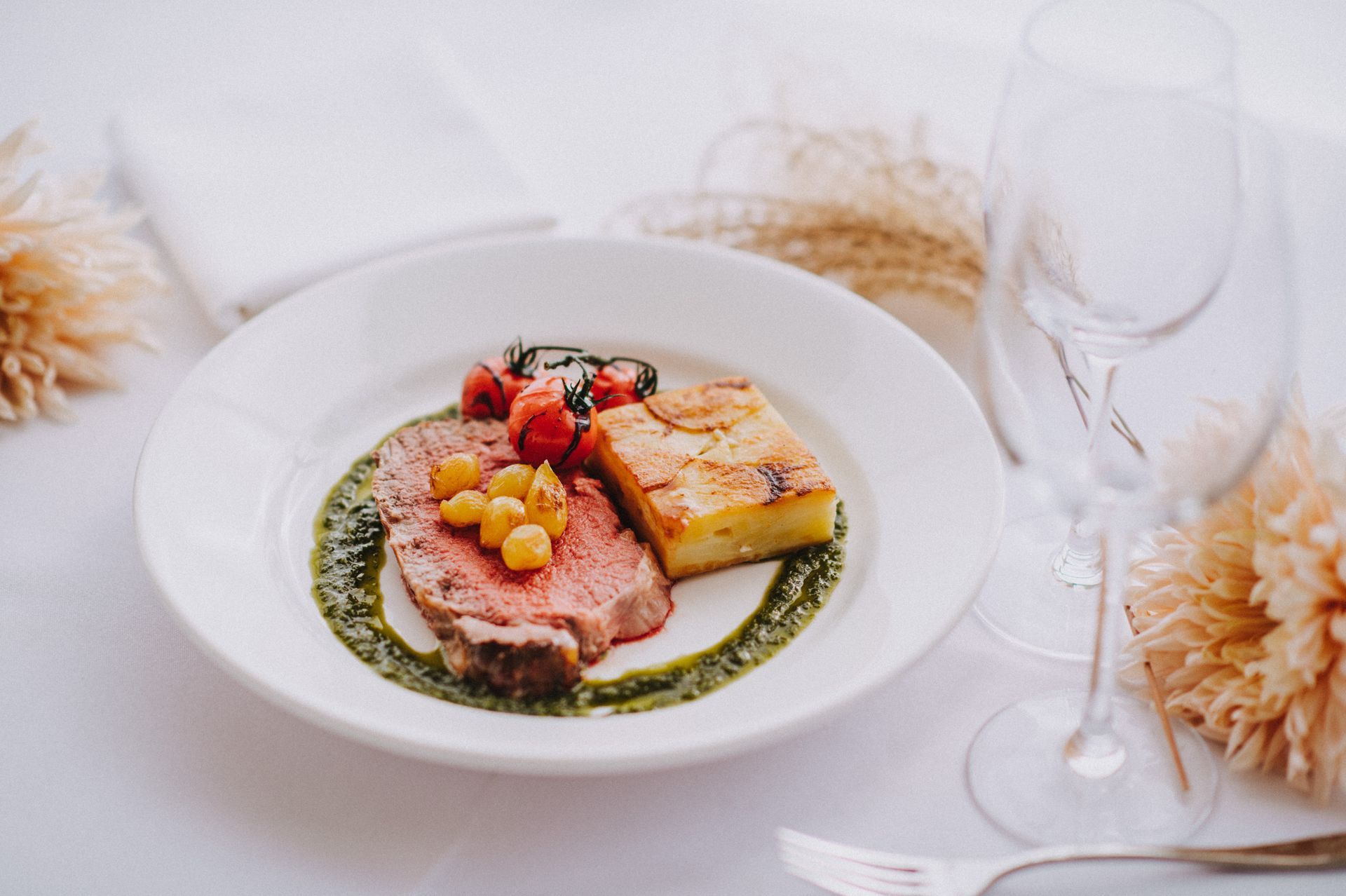 a white plate topped with a steak and potatoes on a table .