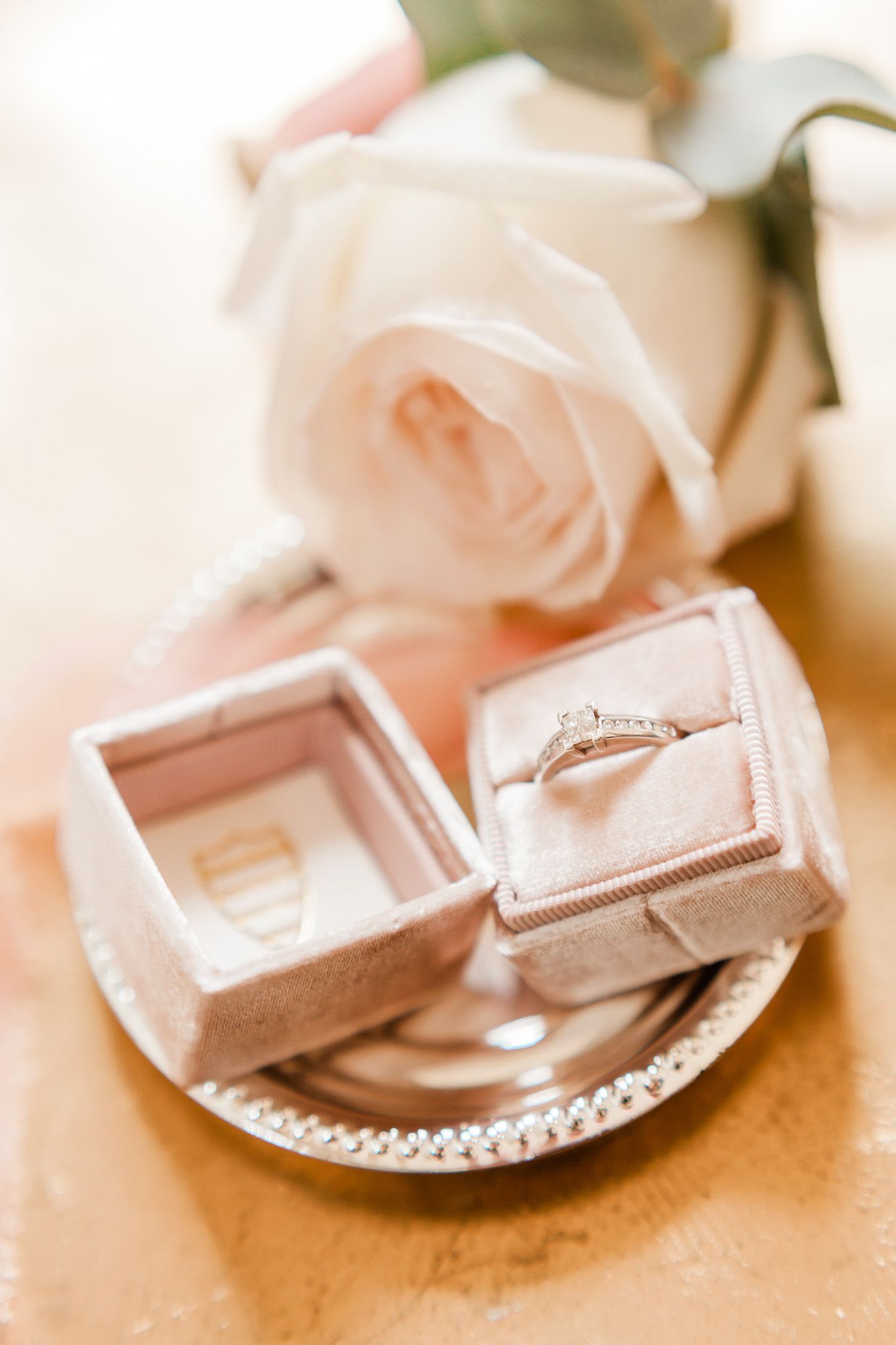 a close up of a wedding ring in a box on a plate.
