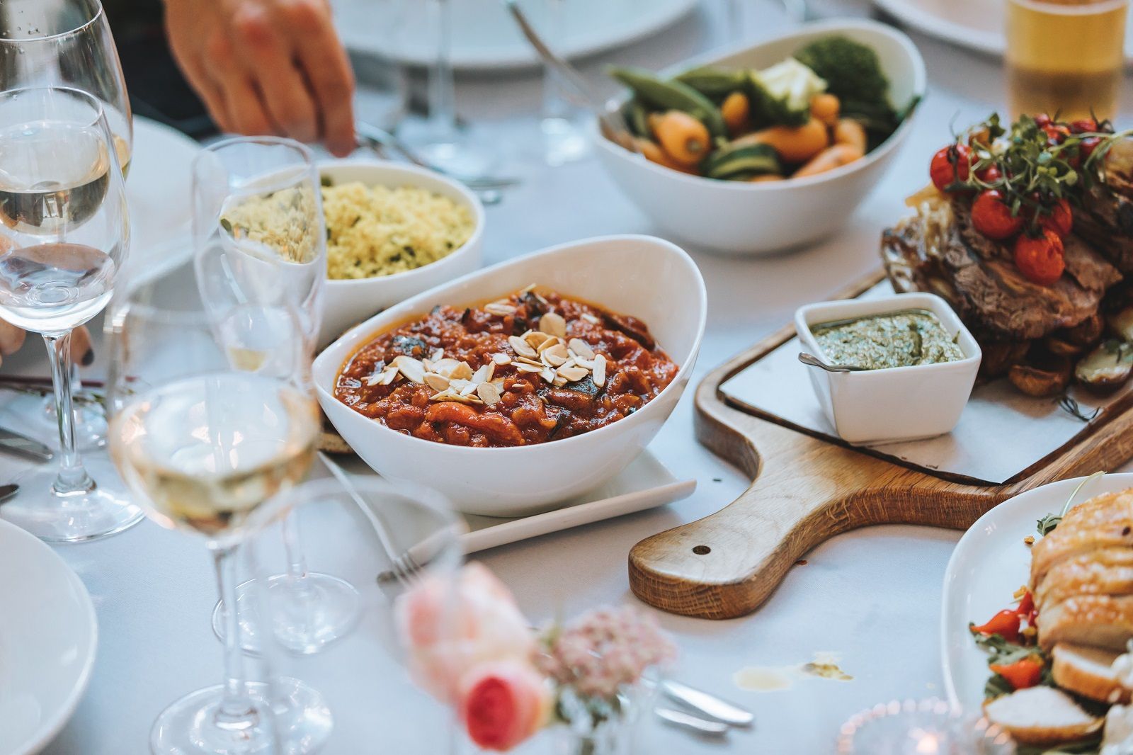 a table topped with bowls of food and wine glasses .
