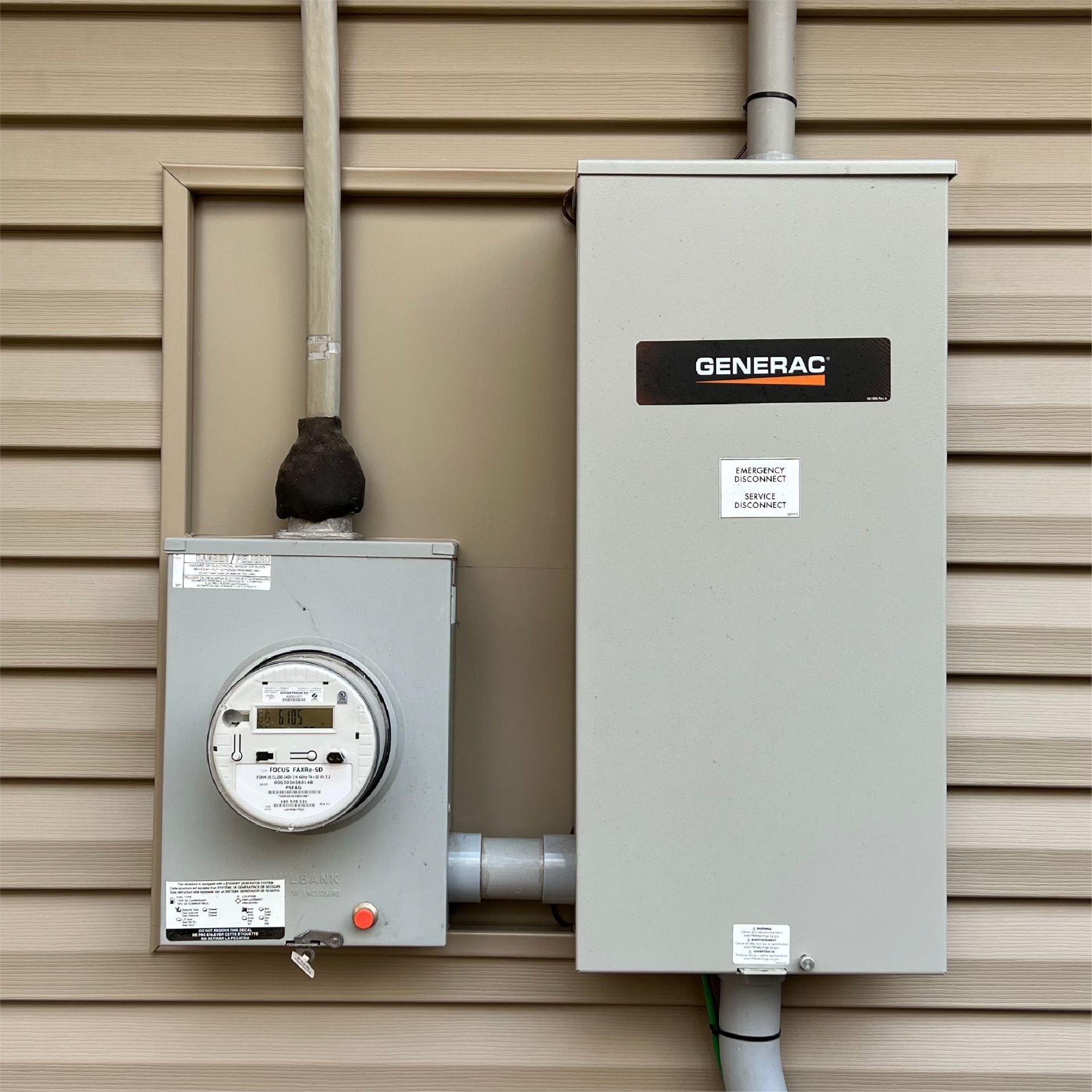 Electrical meter and a Generac power transfer switch mounted on a beige siding wall.