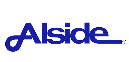 Woman in straw hat smiles, holding wine glass near a lake.