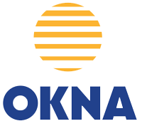 Woman in straw hat smiles, holding wine glass near a lake.