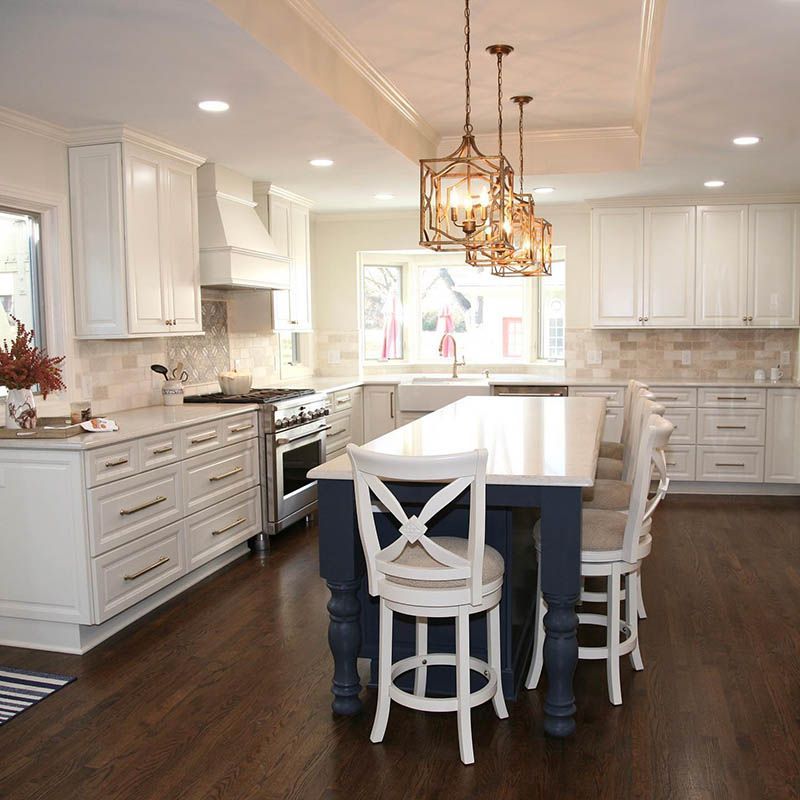 A kitchen with white cabinets and a large island